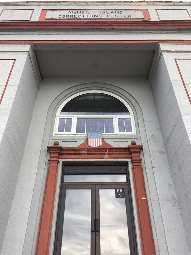 gray and orange door with text above, McNeil Island Corrections Center.