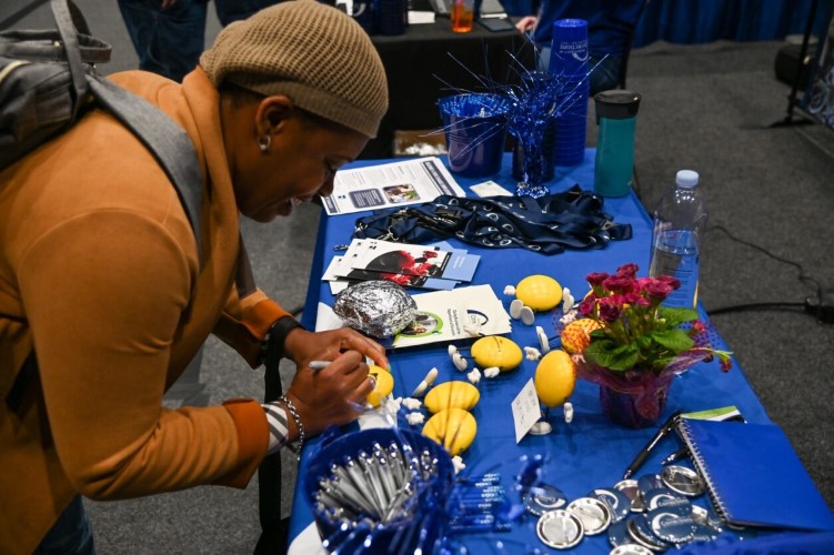 person signing a small display item at DOC's table