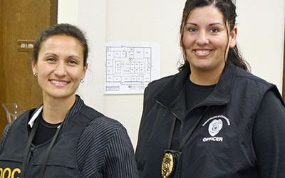 two female community corrections officers smiling at the camera