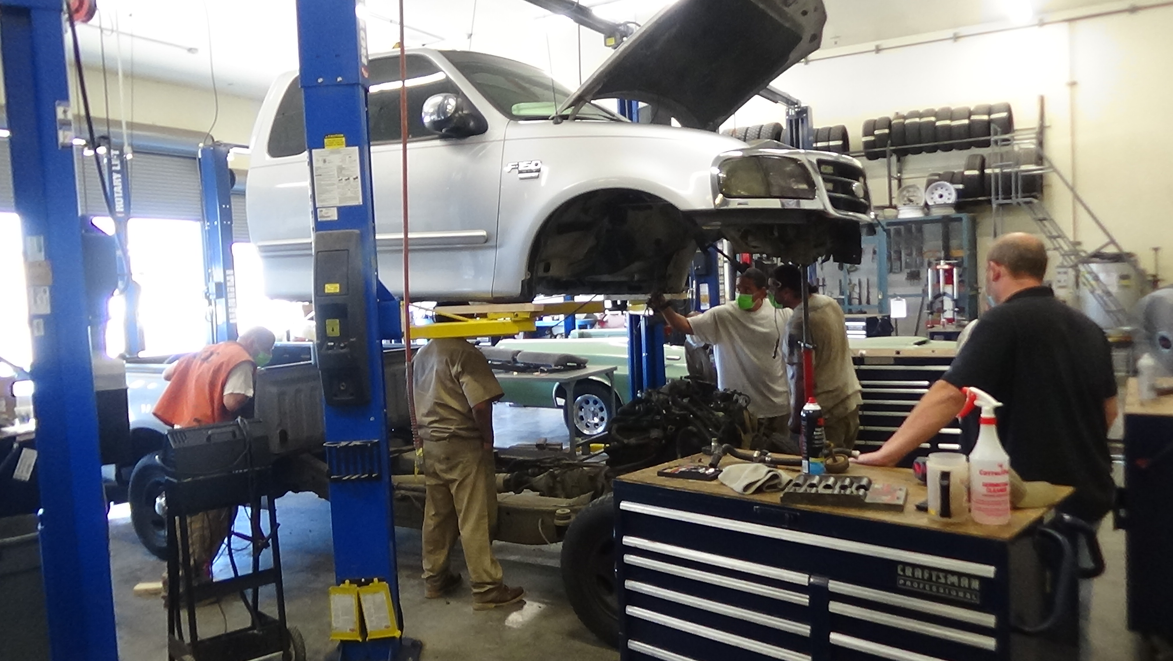 incarcerated individuals working on a car in auto body shop
