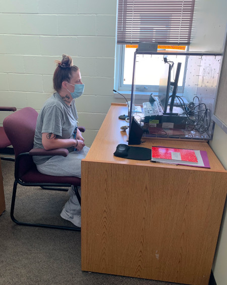 Patient sits at computer desk