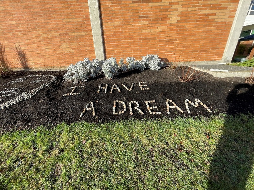 A tribute to Martin Luther King Jr. reads “I Have A Dream” made of rocks in a garden.