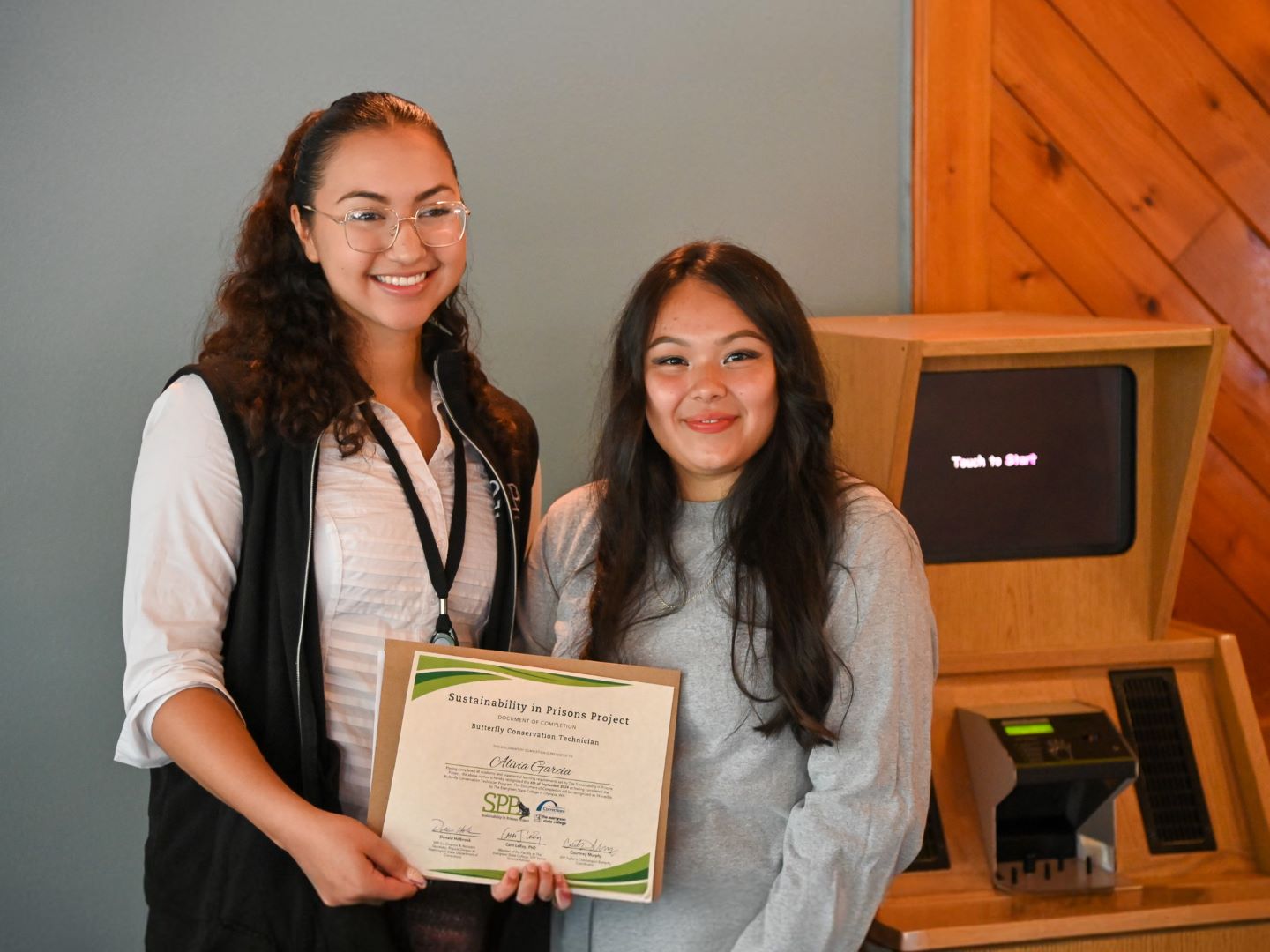 Two women standing side by side holding a certificate.