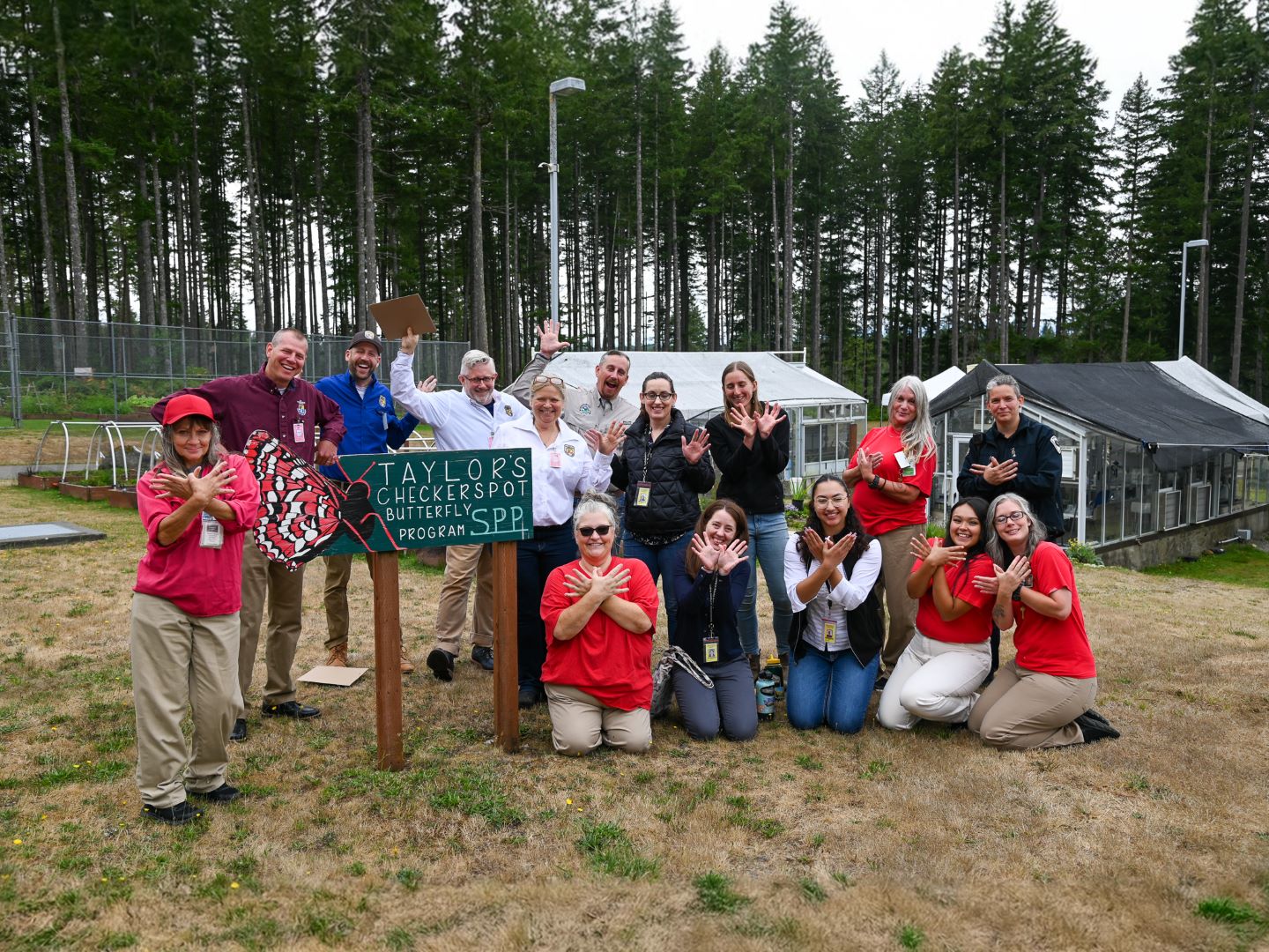 A group of people smiling and waving.