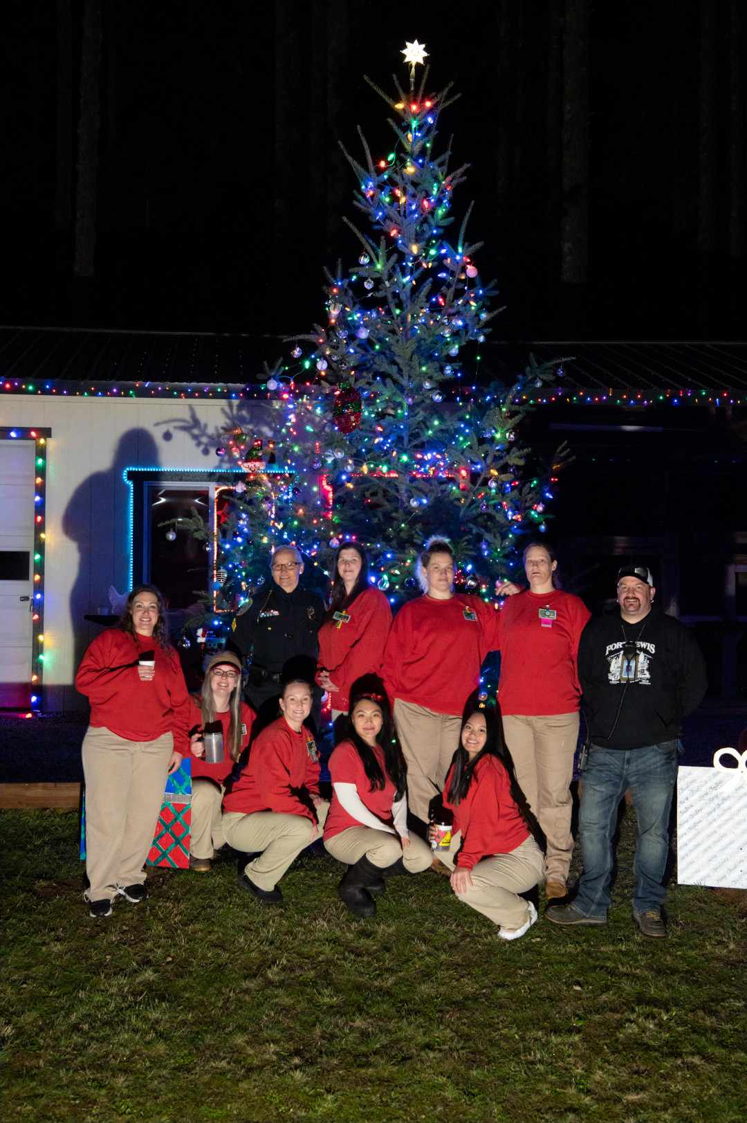 A group posing for a photo in front of a tree.