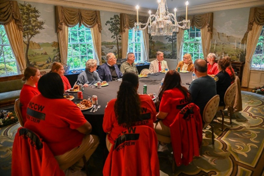 Group sitting down to eat lunch together..