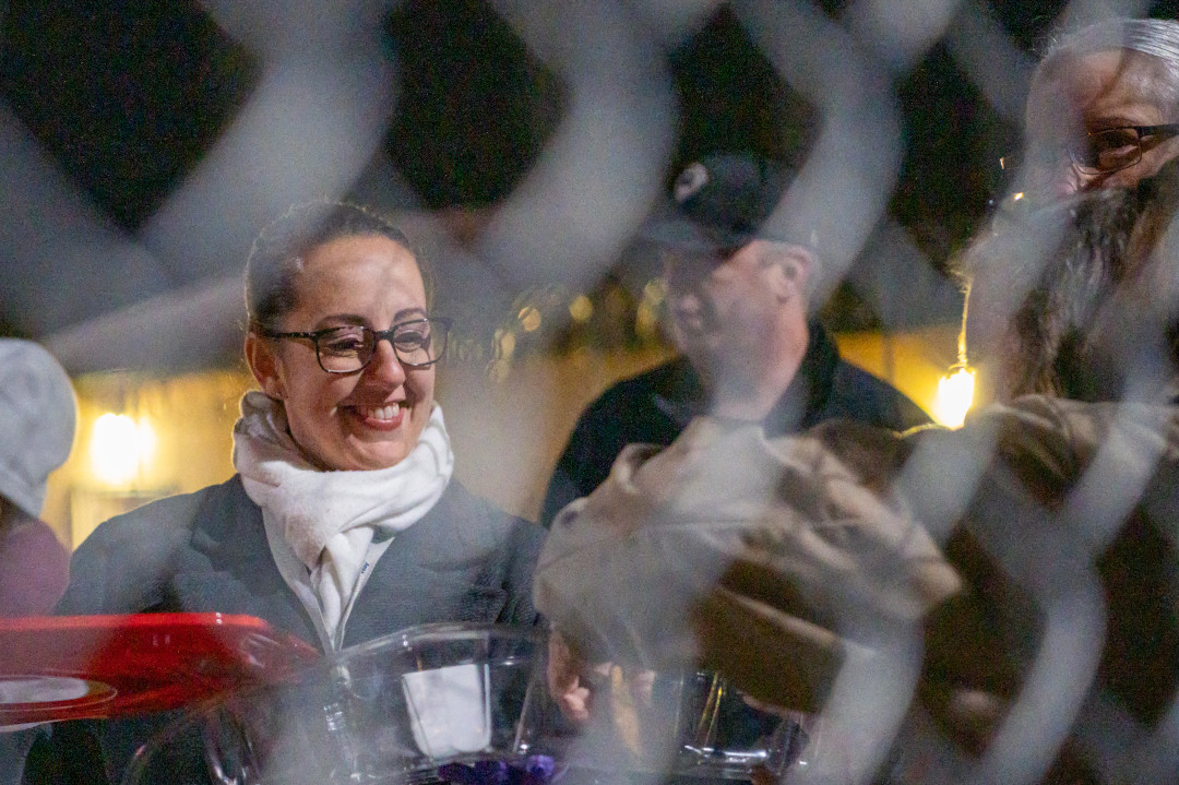 A woman handing out cookies to others nearby.