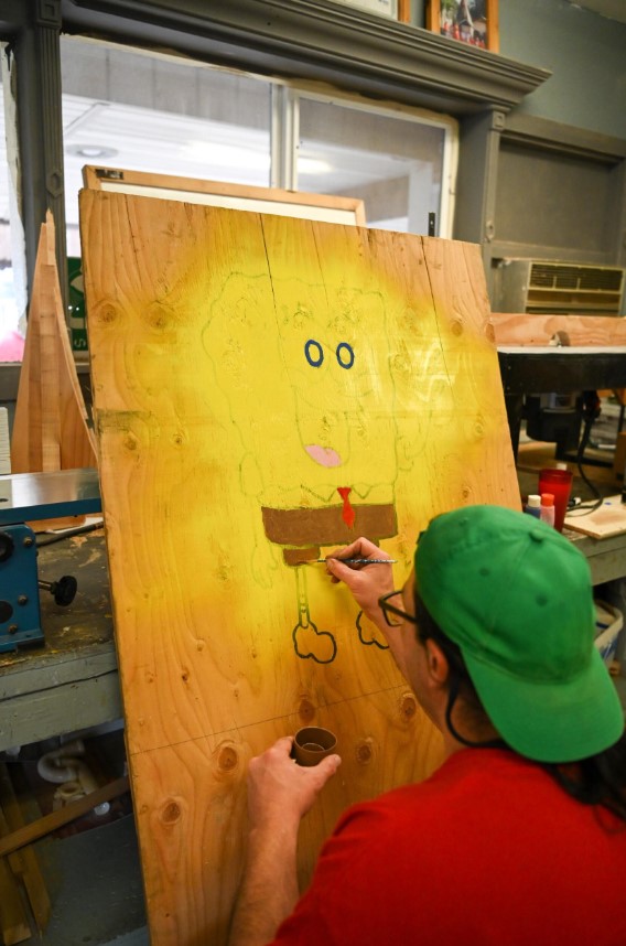 Man painting on a wood canvas