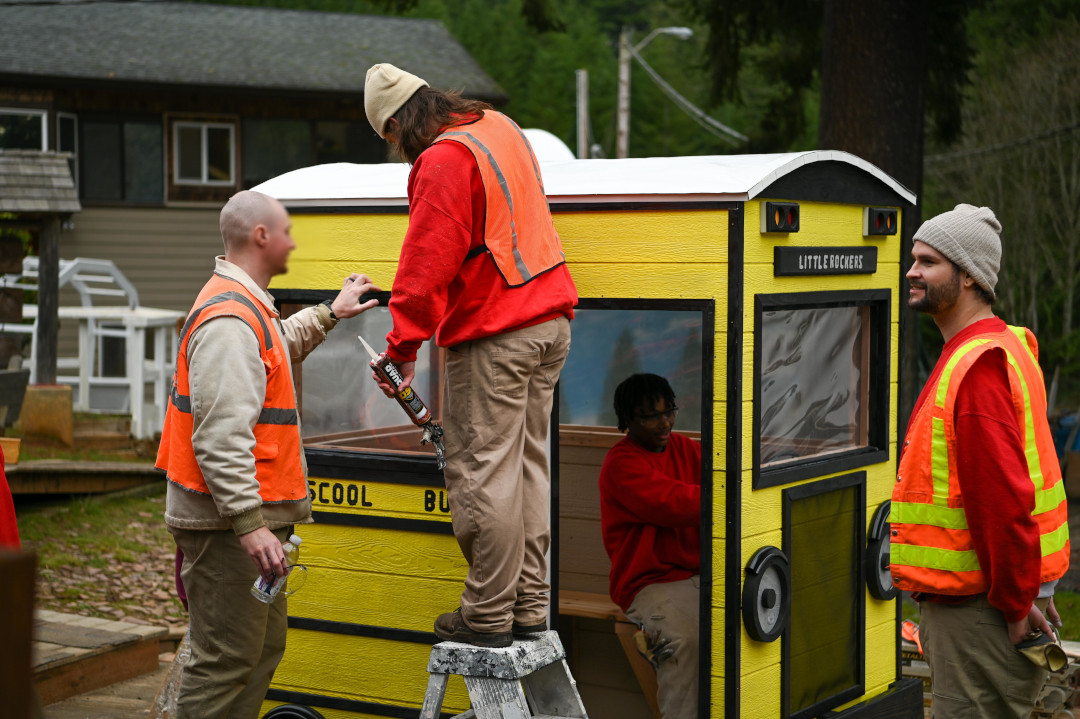 Group of men working together on a bus stop.