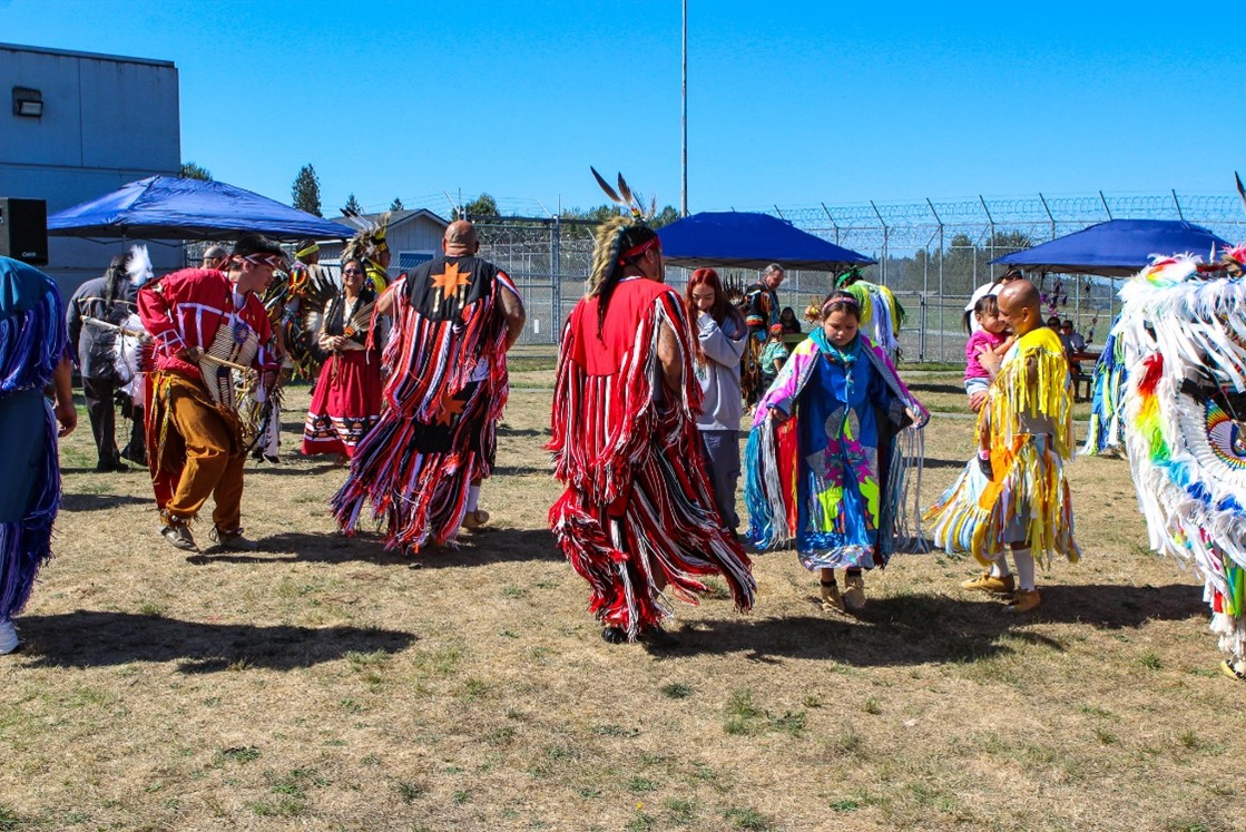 Participants dance together at powwow.