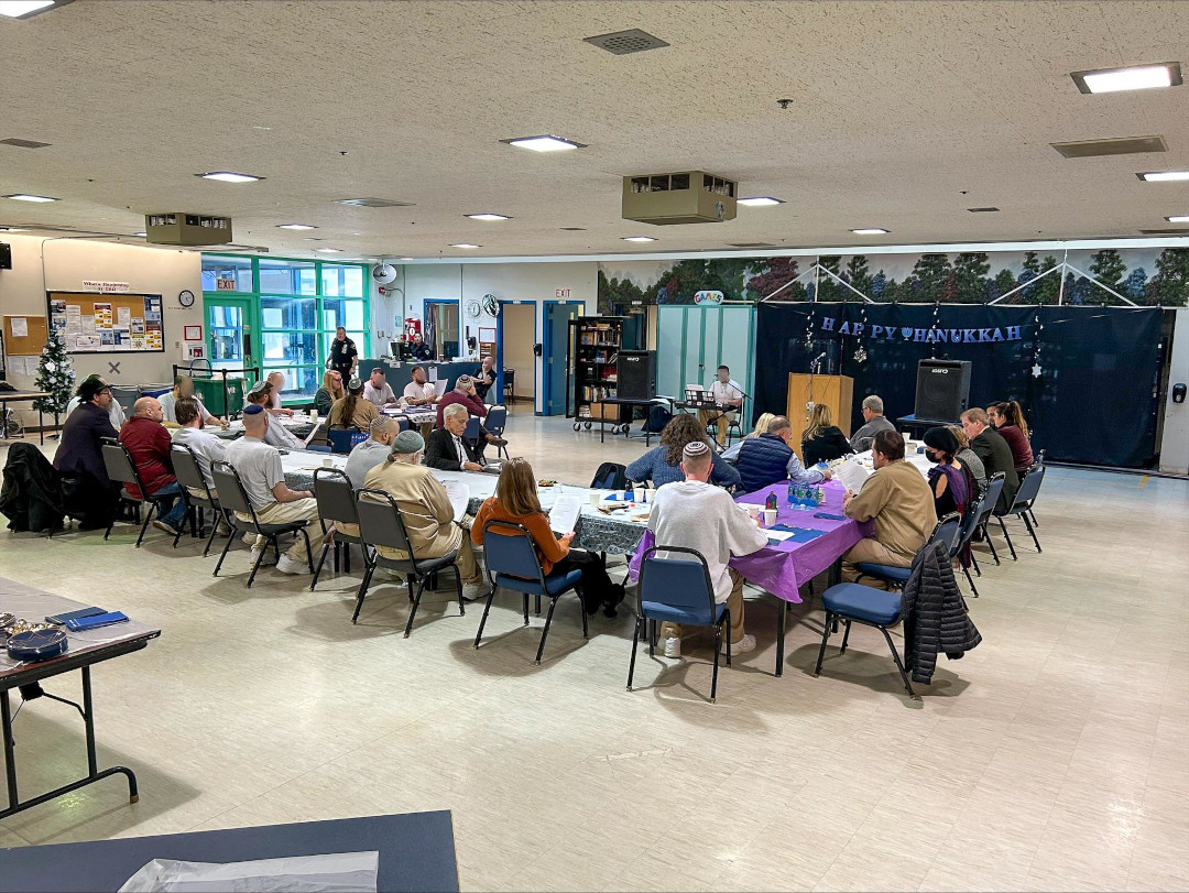 people sitting in a cafeteria watching someone play the keyboard
