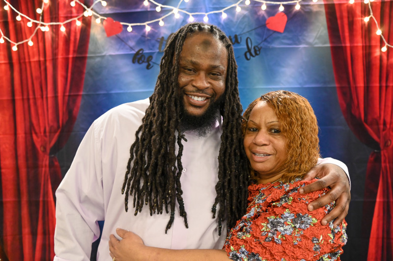Incarcerated individual Omar Norman and his mother take a photo at the booth